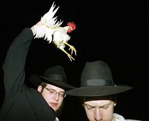 Two Orthodox Jews swing a chicken during Kapparot. Photo: Michael Francis McElroy