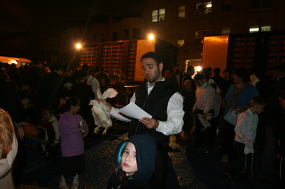An Orthodox Jewish man swings a chicken over his daughter's head during the kaparot ritual in Crown Heights, Brooklyn. Photo: Marlow Stern
